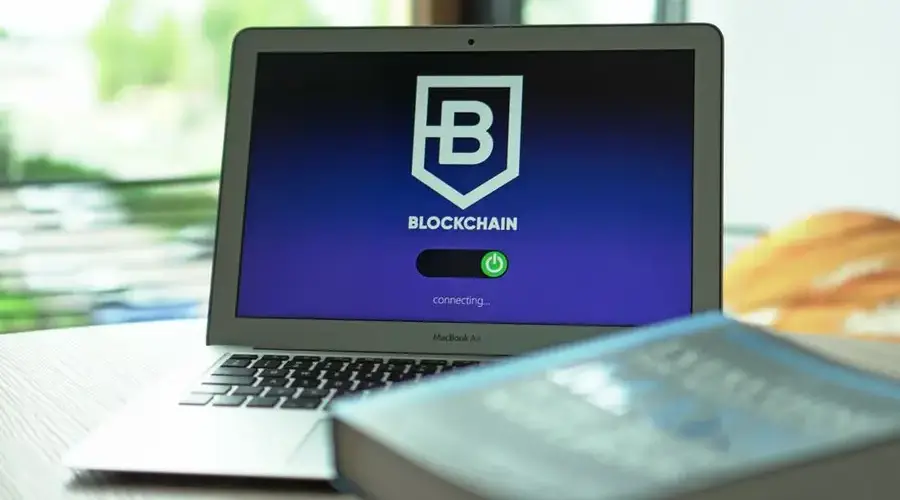 Laptop with blockchain application interface connecting. Ideal for tech and crypto themes.