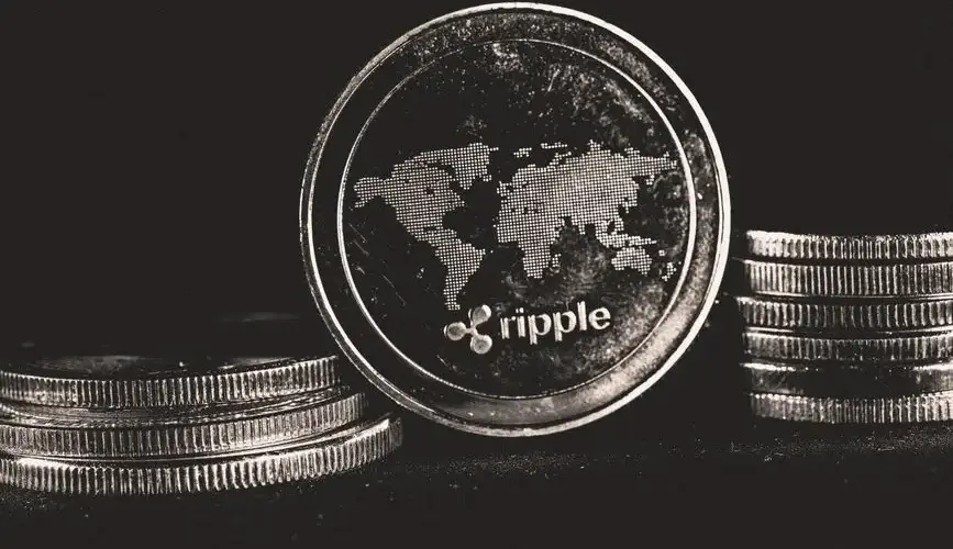 A detailed shot of a Ripple coin with a world map design on a black background.