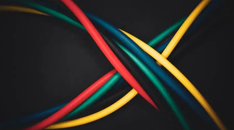 Multi-colored cables intertwined against a dark background, showing technology connections.