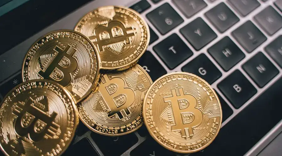 Close-up of multiple Bitcoin coins on a laptop keyboard symbolizing digital currency and cryptocurrency trading.