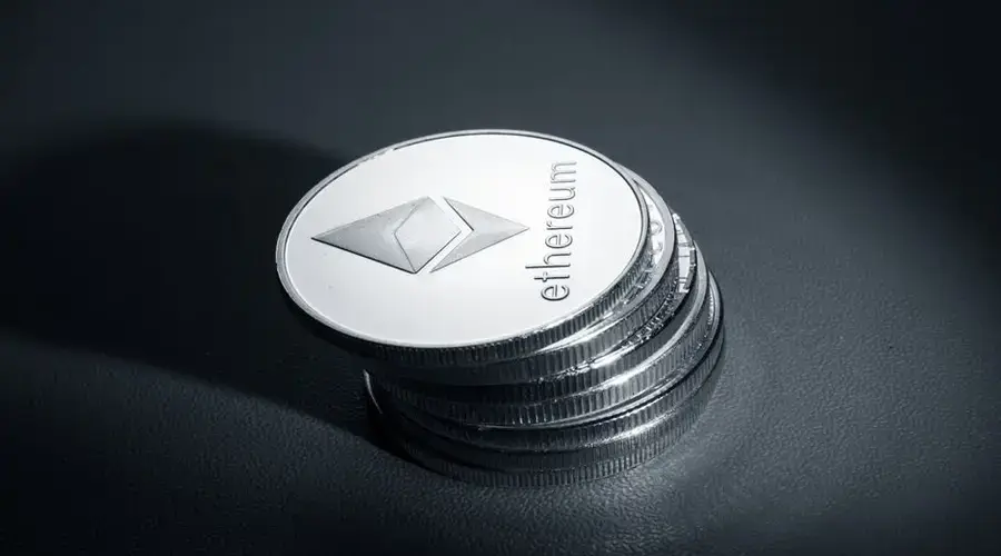 Close-up of stacked Ethereum coins on a dark textured surface, symbolizing modern cryptocurrency.