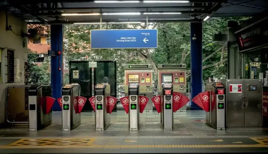 Empty urban transit station with ticket gates, signage, and vending machines.