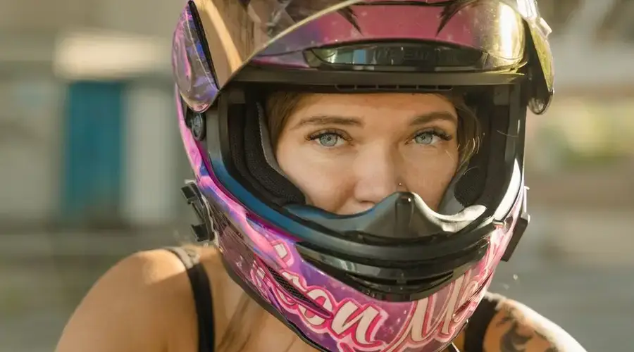 A close-up headshot of a woman wearing a colorful helmet, symbolizing adventure and safety.
