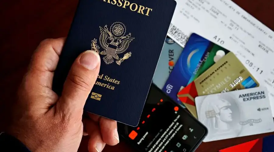 US passport with credit cards and travel documents on a table, travel preparation concept.