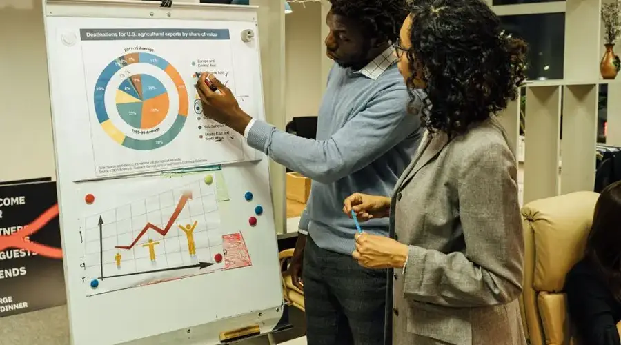 Colleagues discussing data on agricultural exports in a modern office.