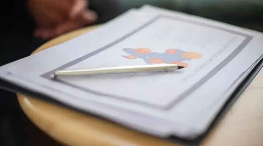 Close-up of business document and pen on a round table, perfect for office and corporate themes.