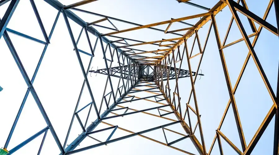 Looking up at a geometric power transmission tower in Depok, Indonesia.