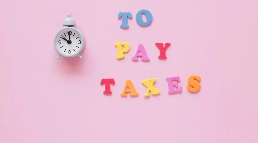 Creative tax payment reminder with clock and colorful letters on a pink background.