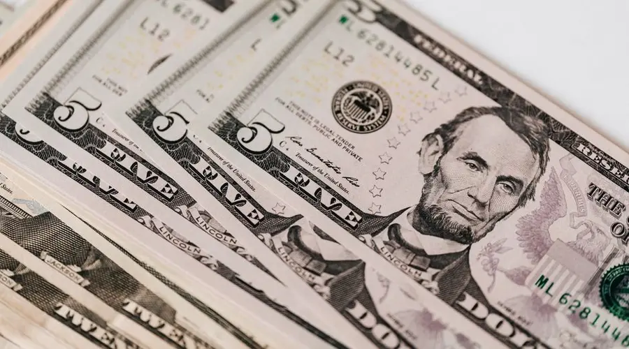 Top view of stack of US dollar banknotes placed together on white background