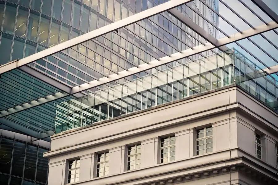 High-angle view of modern glass building with steel structure in urban city center.
