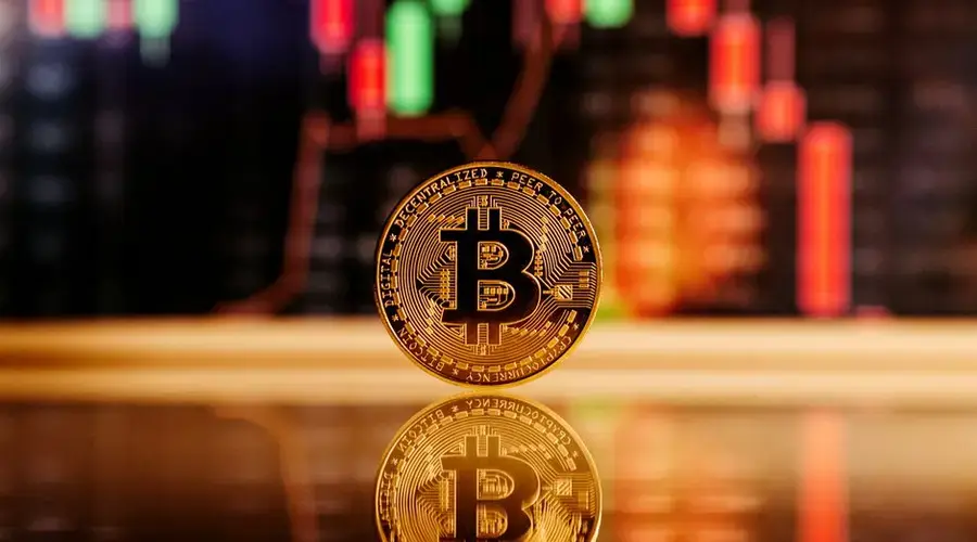 Close-up of a Bitcoin coin with a stock market chart background, symbolizing cryptocurrency trading.