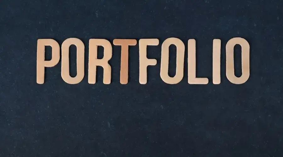 Wooden letters spelling the word 'portfolio' on a textured black background, ideal for creative projects.