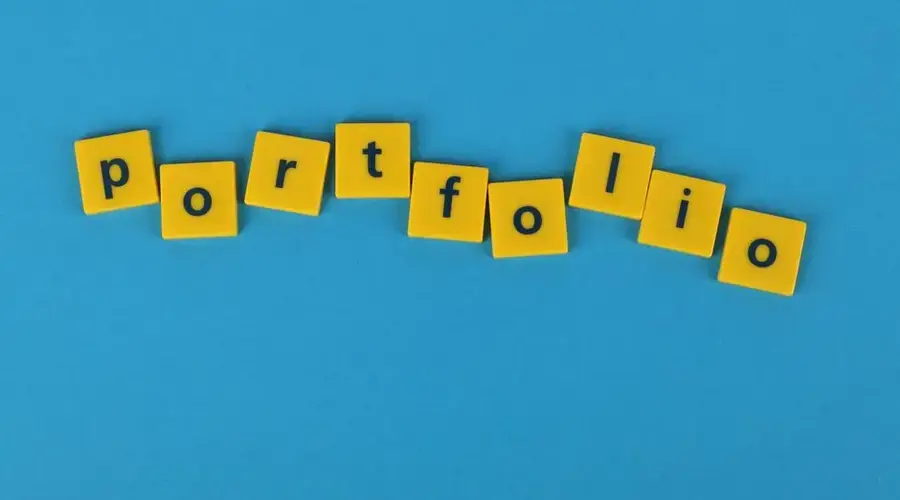 Yellow Scrabble tiles on a blue background spelling 'portfolio'. Perfect for business themes.