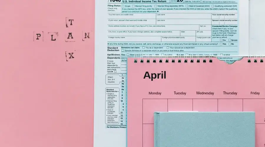 Tax-related items on a pink background, including forms and a calendar.