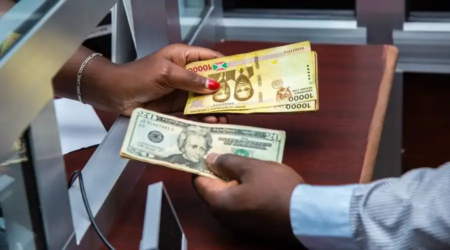 Burundian franc and US dollar exchange transaction at bank counter.