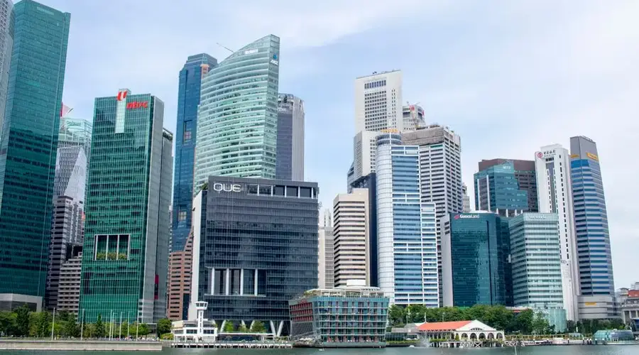 Explore the modern skyline of Singapore with iconic skyscrapers under a clear blue sky.