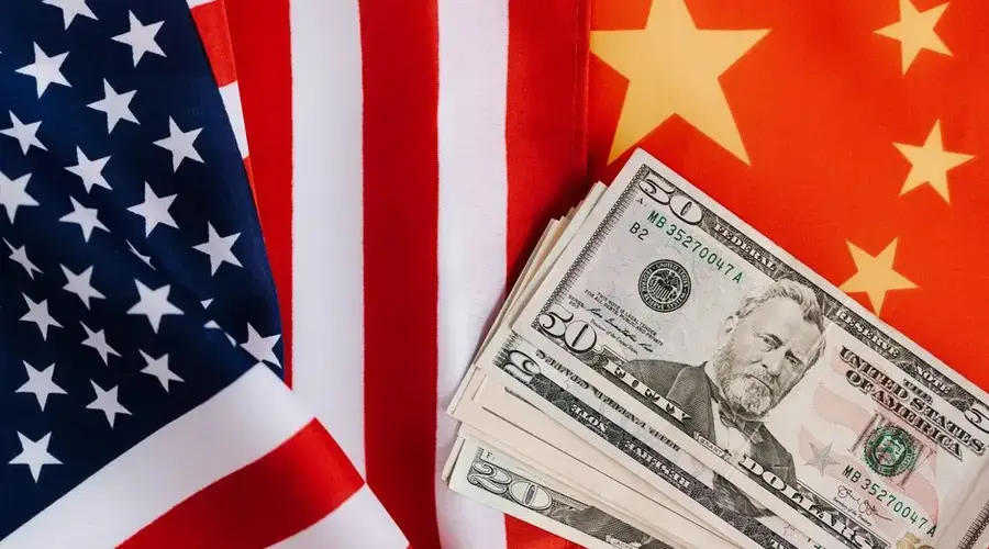 From above of United States banknotes placed on national flags of America and China illustrating international trade concept