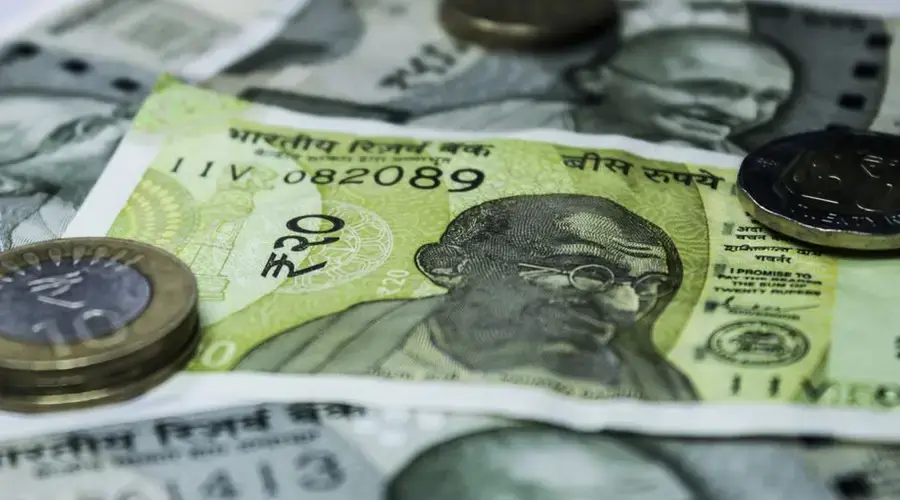 Close-up shot of Indian currency notes and coins, highlighting economic themes.
