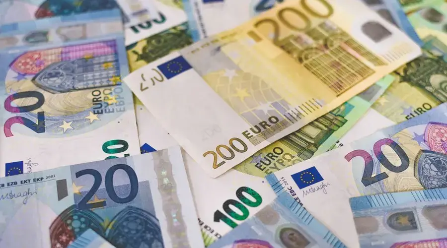 Close-up of various Euro banknotes scattered on a surface, highlighting European currency.