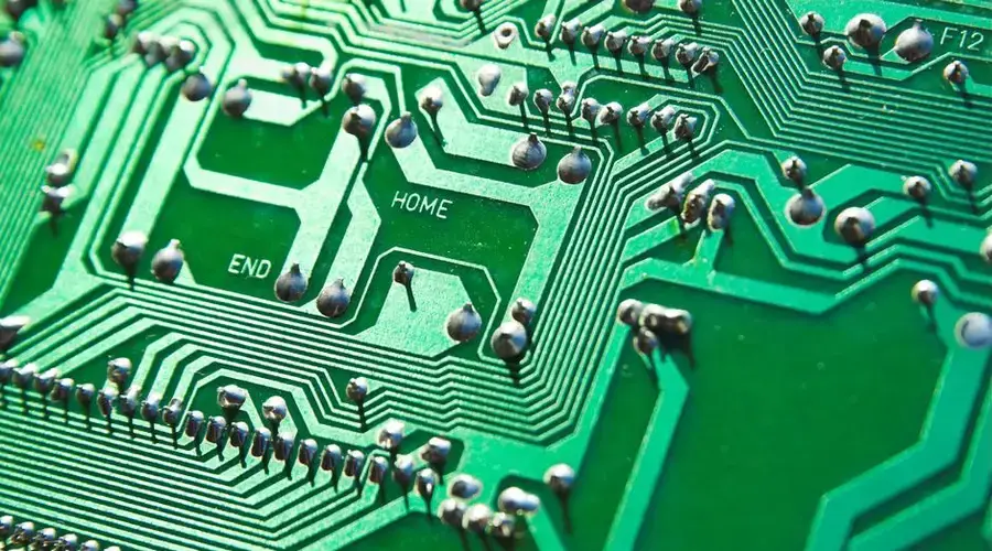 Detailed view of green circuit board with visible chips and pathways, highlighting technology elements.