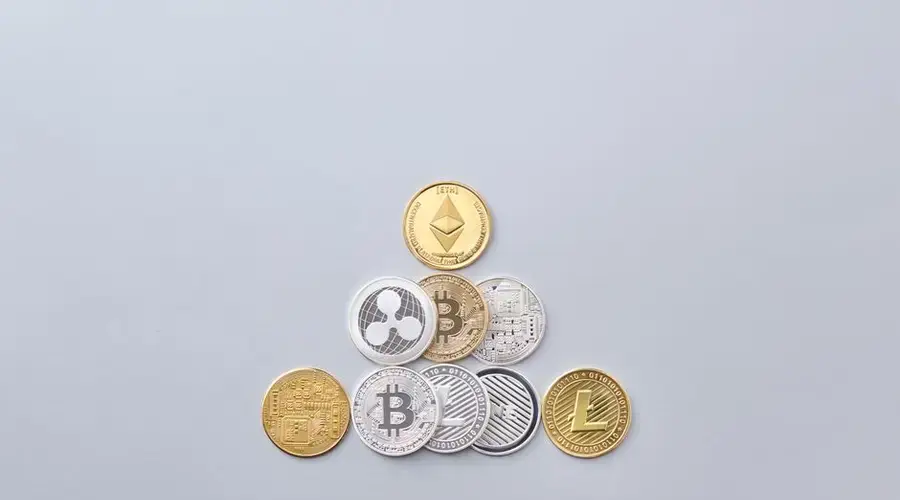 Minimalist display of cryptocurrency coins including Bitcoin and Ethereum on a gray background.