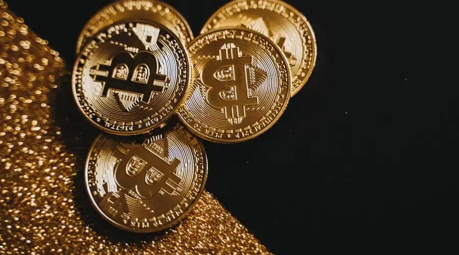 A detailed close-up shot of shiny bitcoin coins resting on a glittery surface, symbolizing wealth in digital currency.