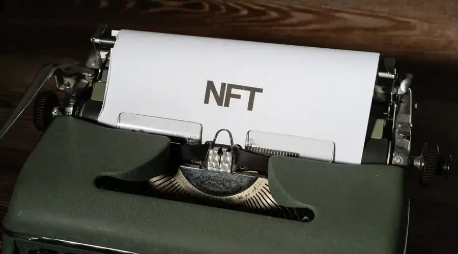 Close-up of a vintage typewriter with the word 'NFT' typed on paper, symbolizing digital innovation.