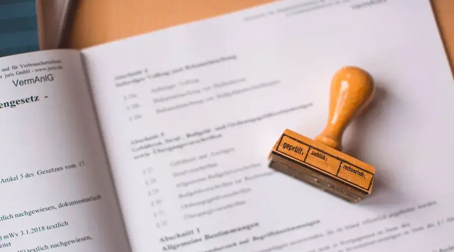 Close-up of a legal document with a wooden stamp placed on top, highlighting verification.