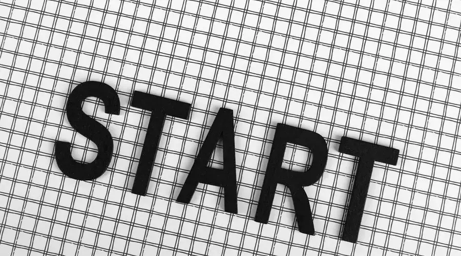 Black letters spelling 'START' on a white grid background, conceptual and minimalistic design.