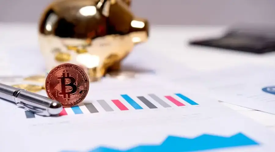 A Bitcoin coin on financial charts with a gold piggy bank, symbolizing modern finance.