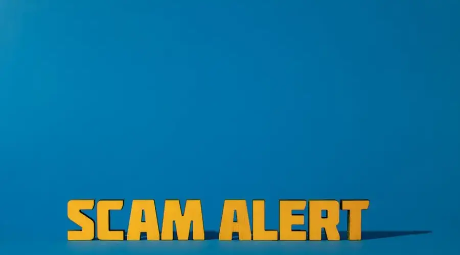 Bold yellow 'Scam Alert' text on a vivid blue surface, emphasizing warning and caution.