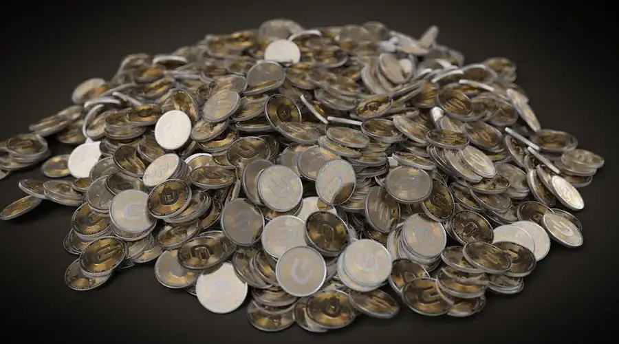 A collection of silver and gold cryptocurrency coins stacked on a dark background, symbolizing digital wealth.