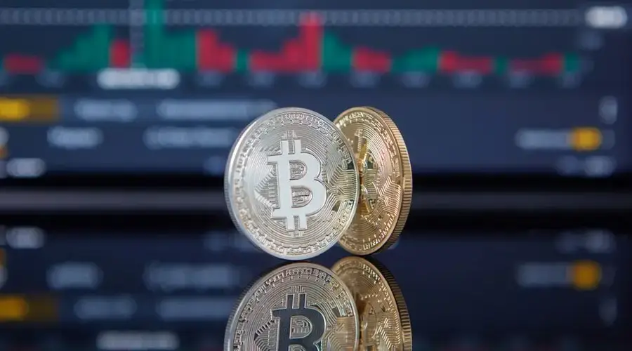Bitcoin coins with a stock market background representing cryptocurrency and trading.
