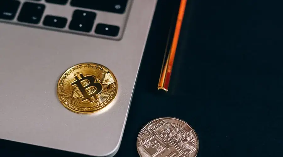 Close-up of Bitcoin and cryptocurrency coins on a laptop, symbolizing digital finance.