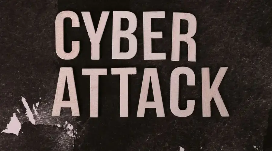 Text 'Cyber Attack' on textured dark paper highlights digital security threat concept.