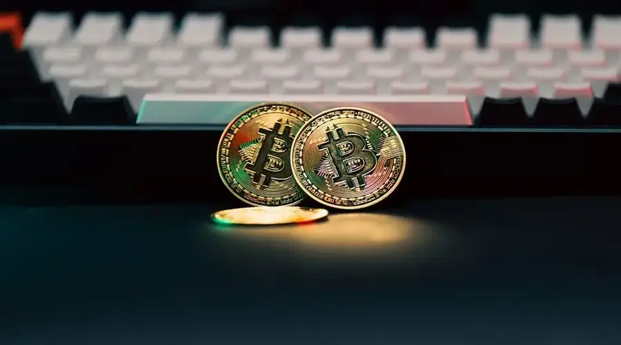 Golden Bitcoin coins in front of a keyboard, symbolizing digital currency and finance
