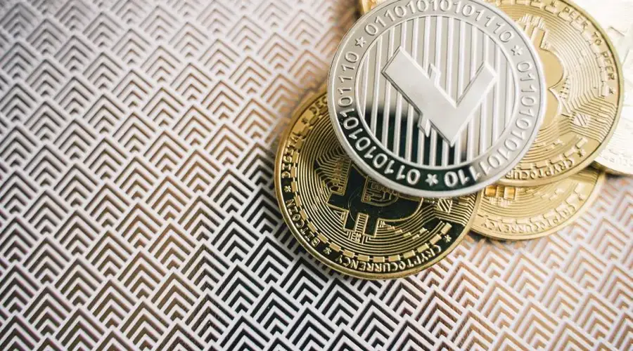 A detailed shot of Litecoin and Bitcoin coins on a geometric pattern background, highlighting digital currency.