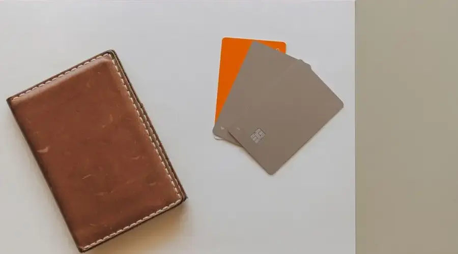 A leather wallet and credit cards on a minimalist background, ideal for financial themes.