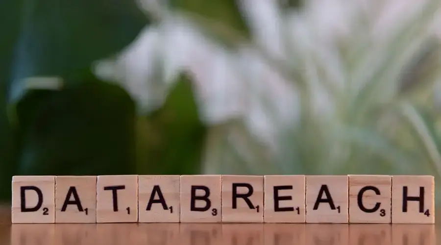 Close-up of Scrabble tiles spelling 'data breach' on a blurred background