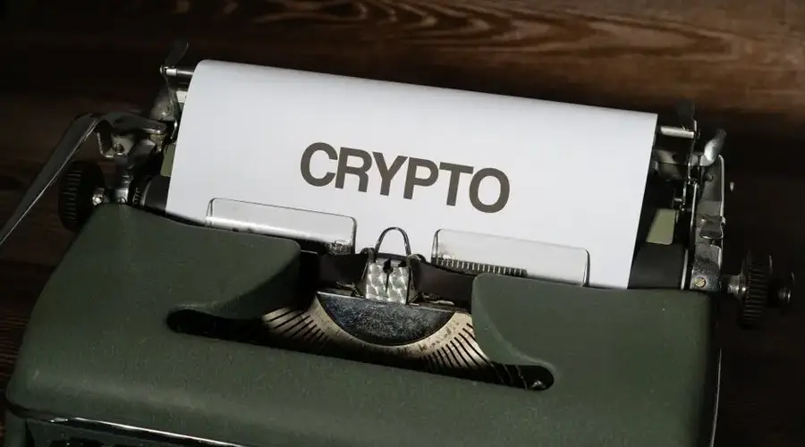 A classic typewriter displaying the word 'crypto' on paper, symbolizing digital currency's vintage connection.