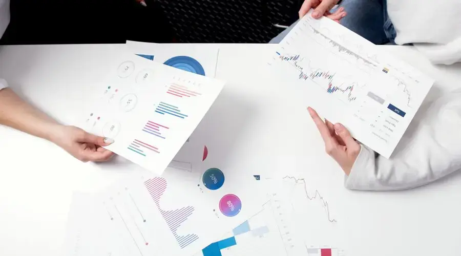 Hands holding business charts and graphs during a meeting, showcasing financial analysis and investment strategy.