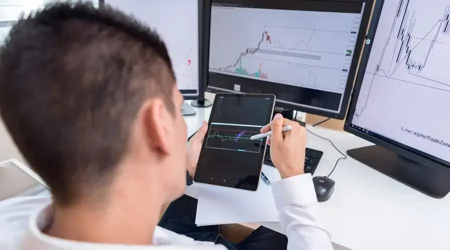 A trader reviewing cryptocurrency charts on a tablet in a modern office setting.