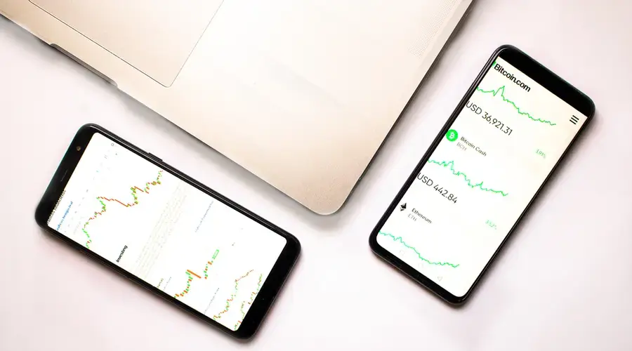 Two smartphones with cryptocurrency data and graphs, ideal for financial insights.