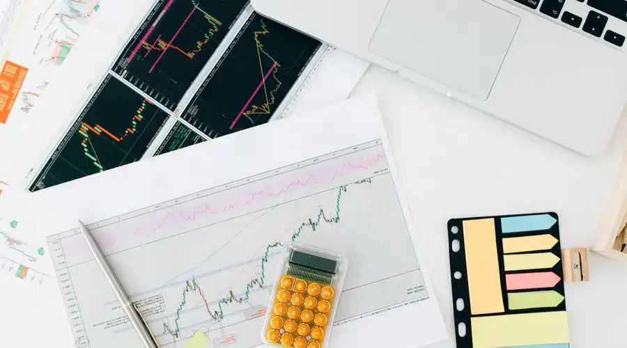 Flat lay of financial charts and tools on office desk, ideal for business and finance concepts.