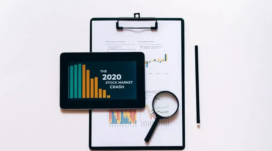 Tablet, magnifying glass, and clipboard for stock market analysis.