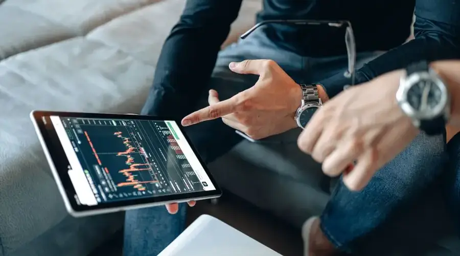 Two people discussing cryptocurrency data on a digital tablet.