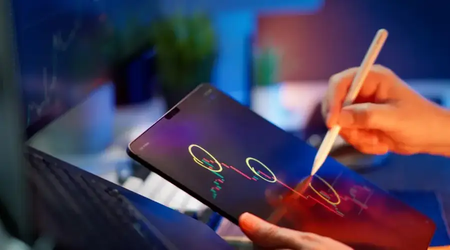 Person analyzing cryptocurrency trends on a tablet with digital pen.