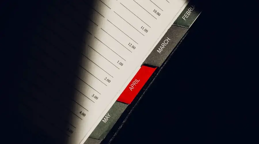 A close-up shot of a planner highlighting the month of April with visible monthly tabs.