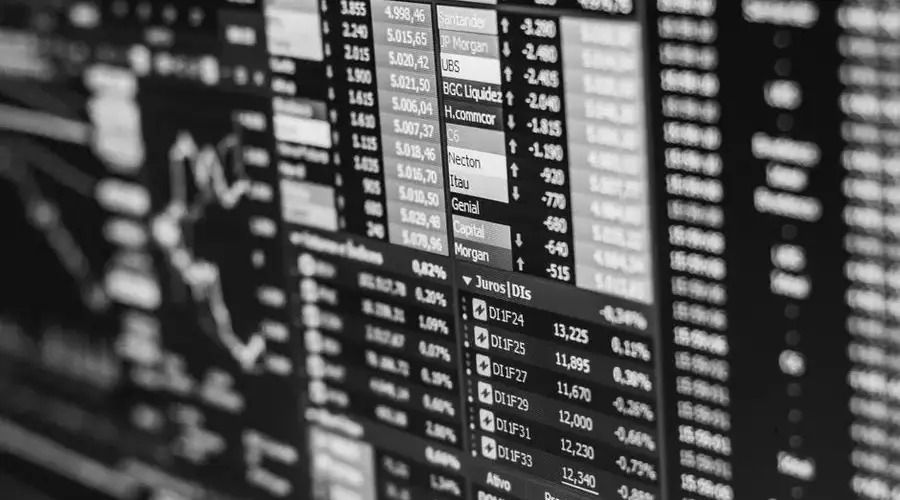 Monochrome image of stock market data on a screen, depicting financial information and trends.