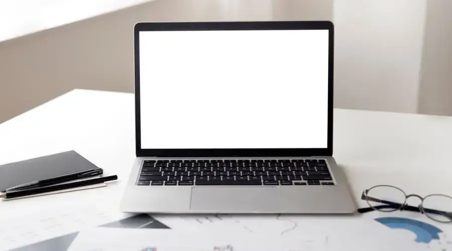 Open laptop with financial documents on a desk, ideal for business and technology themes.